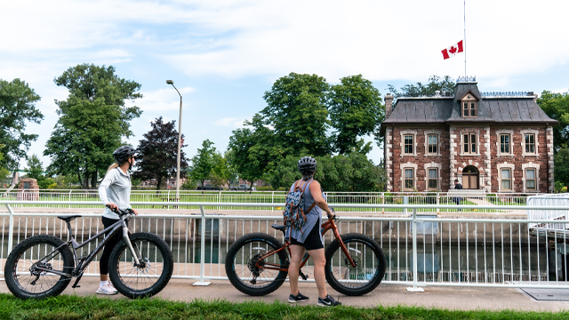Deux amis avec des vélos regardant le canal.