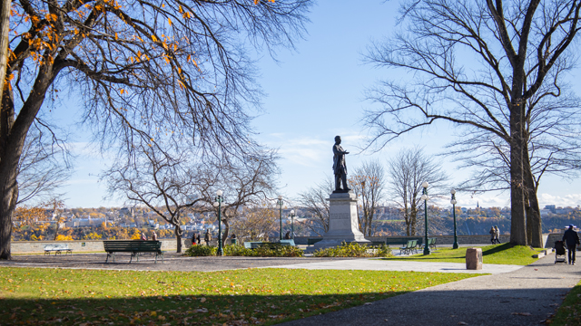 View of Montmorency Park with the statue of Georges-Étienne Cartier in the center, mature trees and Lévis in the background.